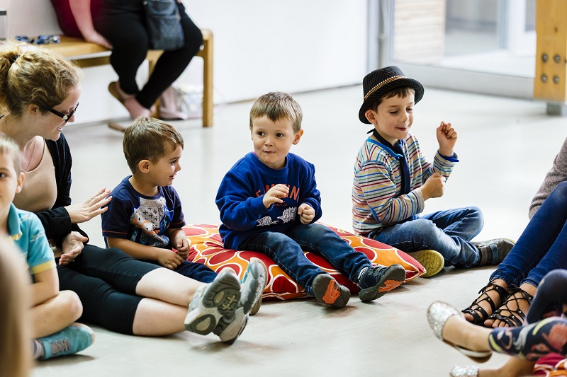 A group of children sit on red and orange cushions on the floor of the gallery at The Point in Doncaster