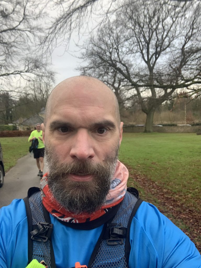 A bearded man takes part in an organised fitness challenge. 
