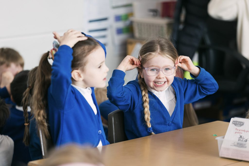 Two pupils smile in primary school.